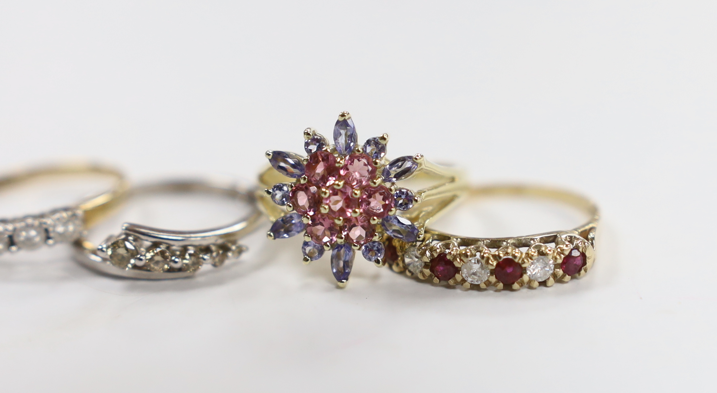 Four assorted modern 9ct gold and gem set rings (two with rubbed hallmarks), including seven stone illusion set diamonds chip and five stone graduated diamond chip